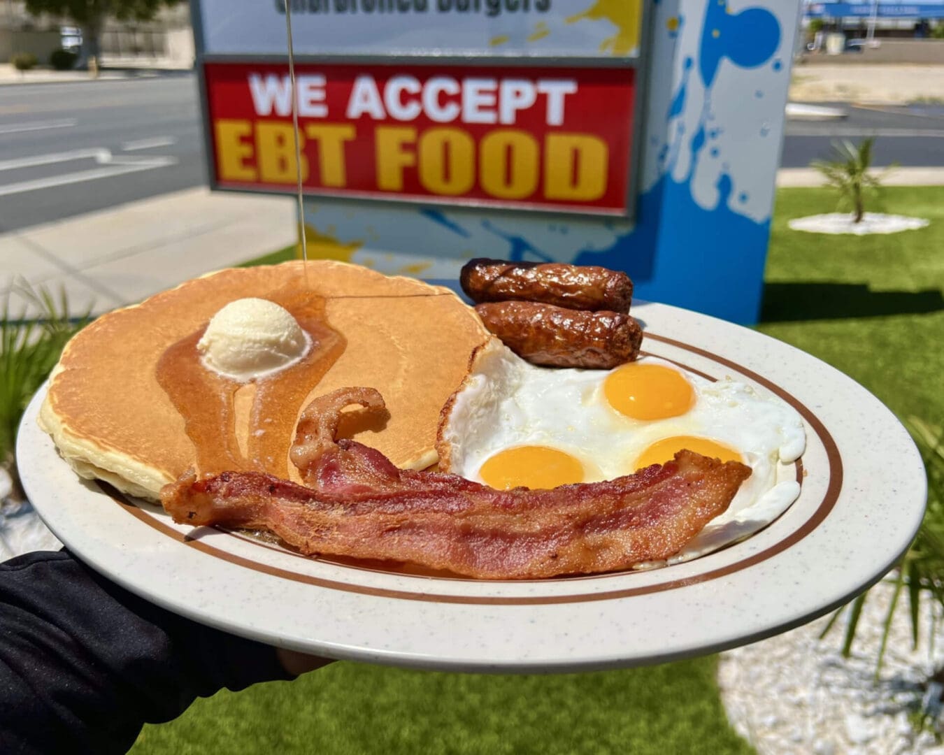 A plate of breakfast food on the grass.